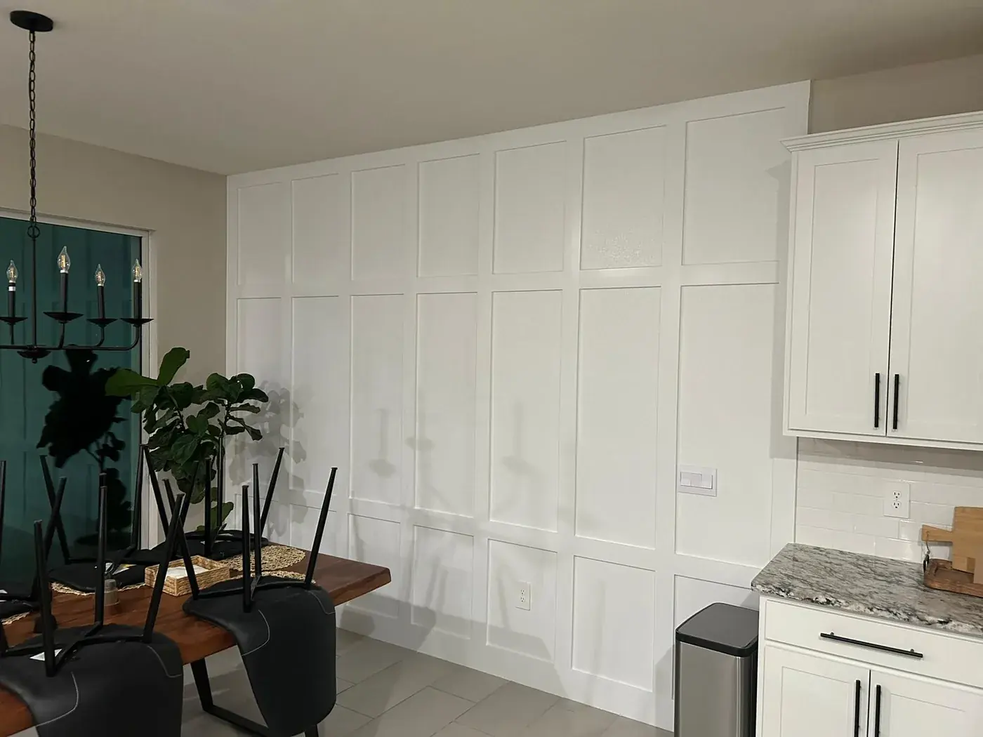 The same dining room wall finished in white, panel grid sharp against the tile floor