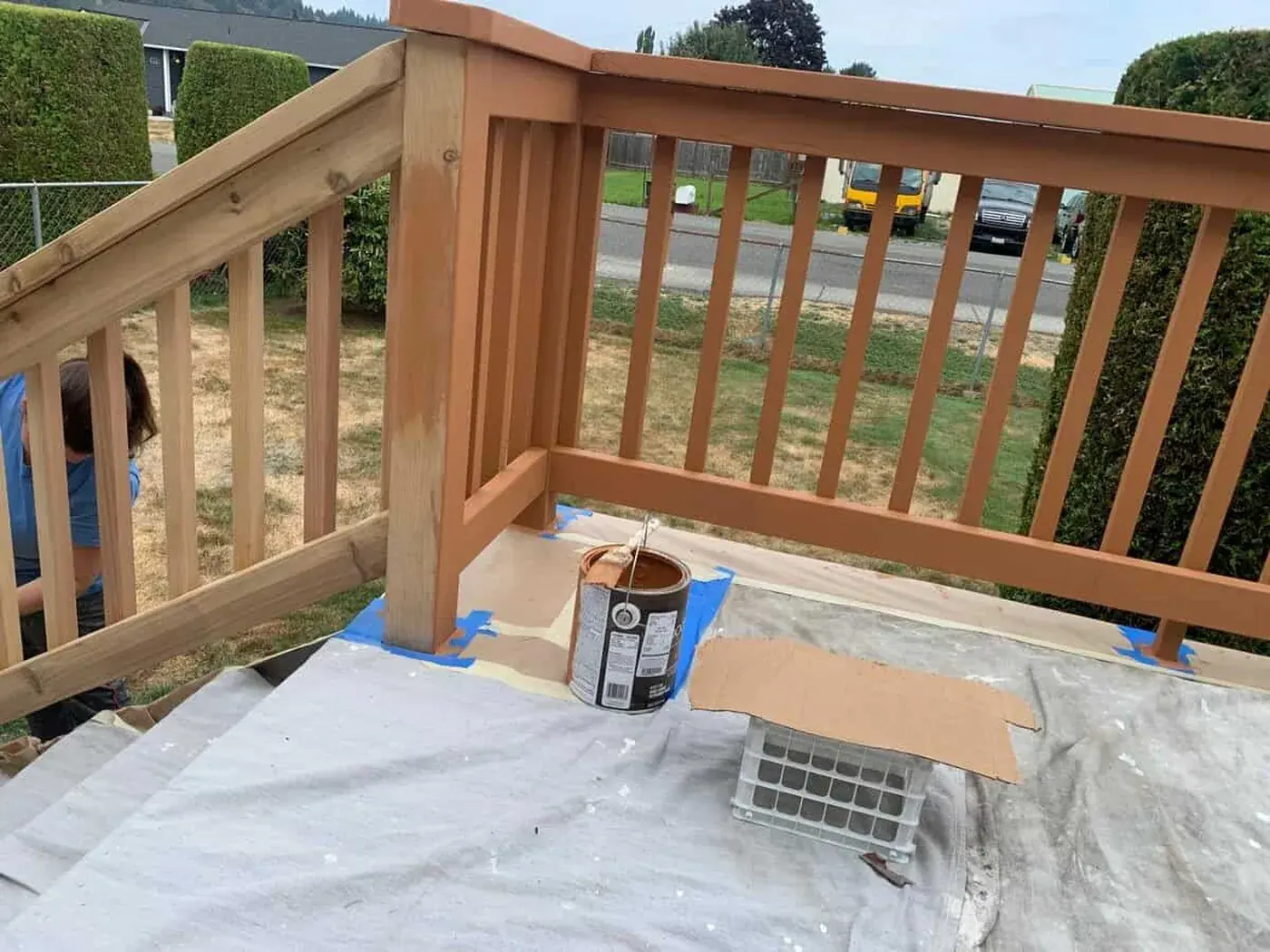 Deck railing part way through staining, the can still on the boards