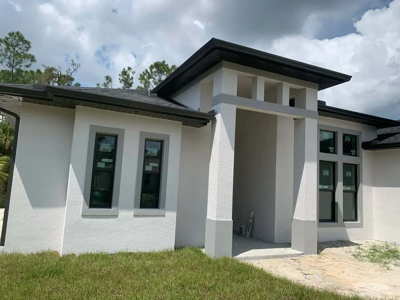Florida new build after its exterior coats, white stucco with grey columns