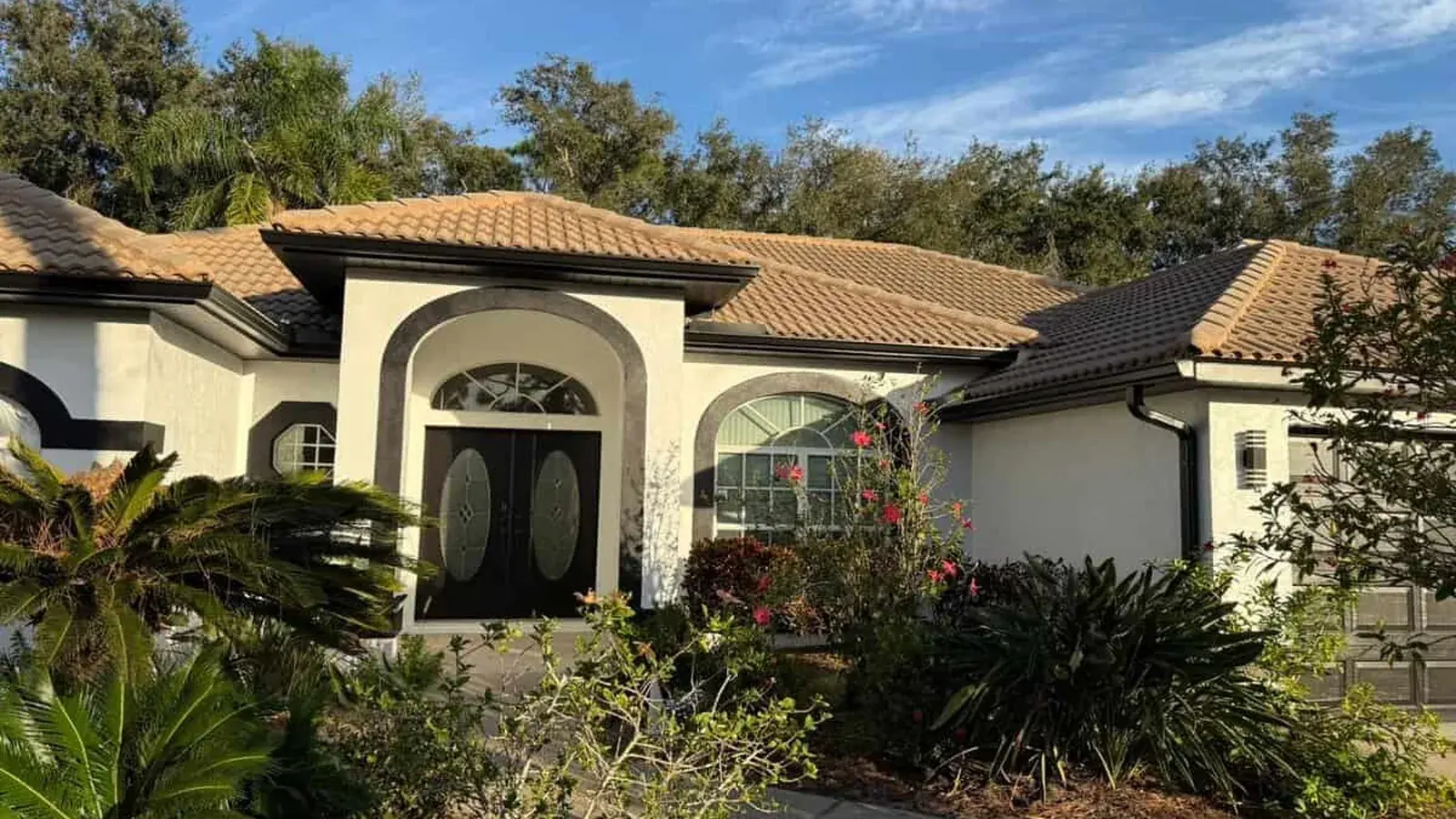 Florida home with a tile roof and arched entry after painting, walls and trim finished
