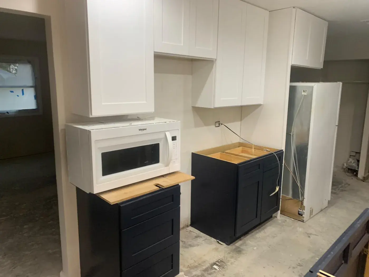 Kitchen with white upper cabinets and deep navy base cabinets