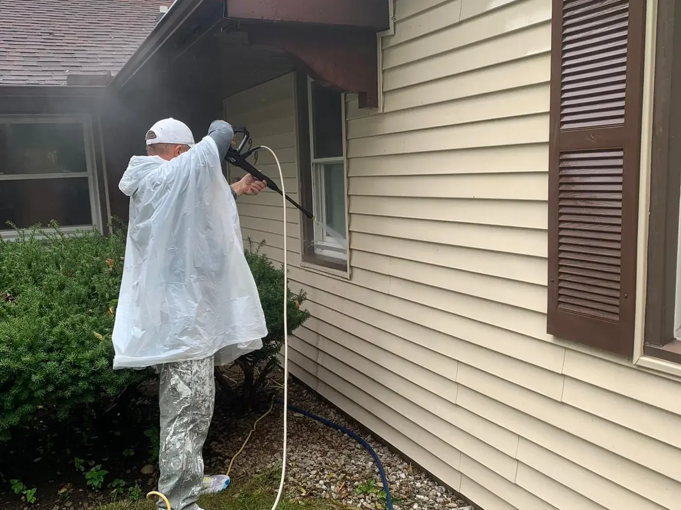 Soft washing the upper siding and soffit of a house