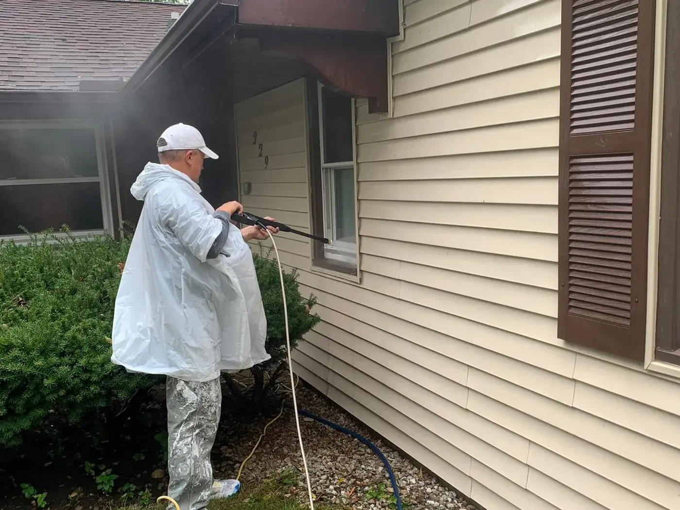 Soft washing the siding of a house before repainting