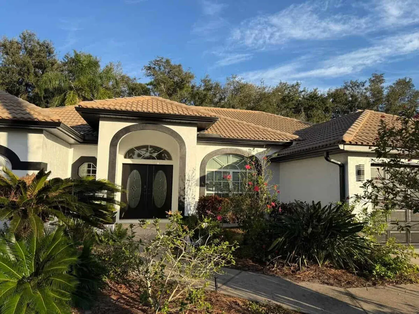 Sarasota home with a barrel tile roof, arched entry and repainted stucco walls