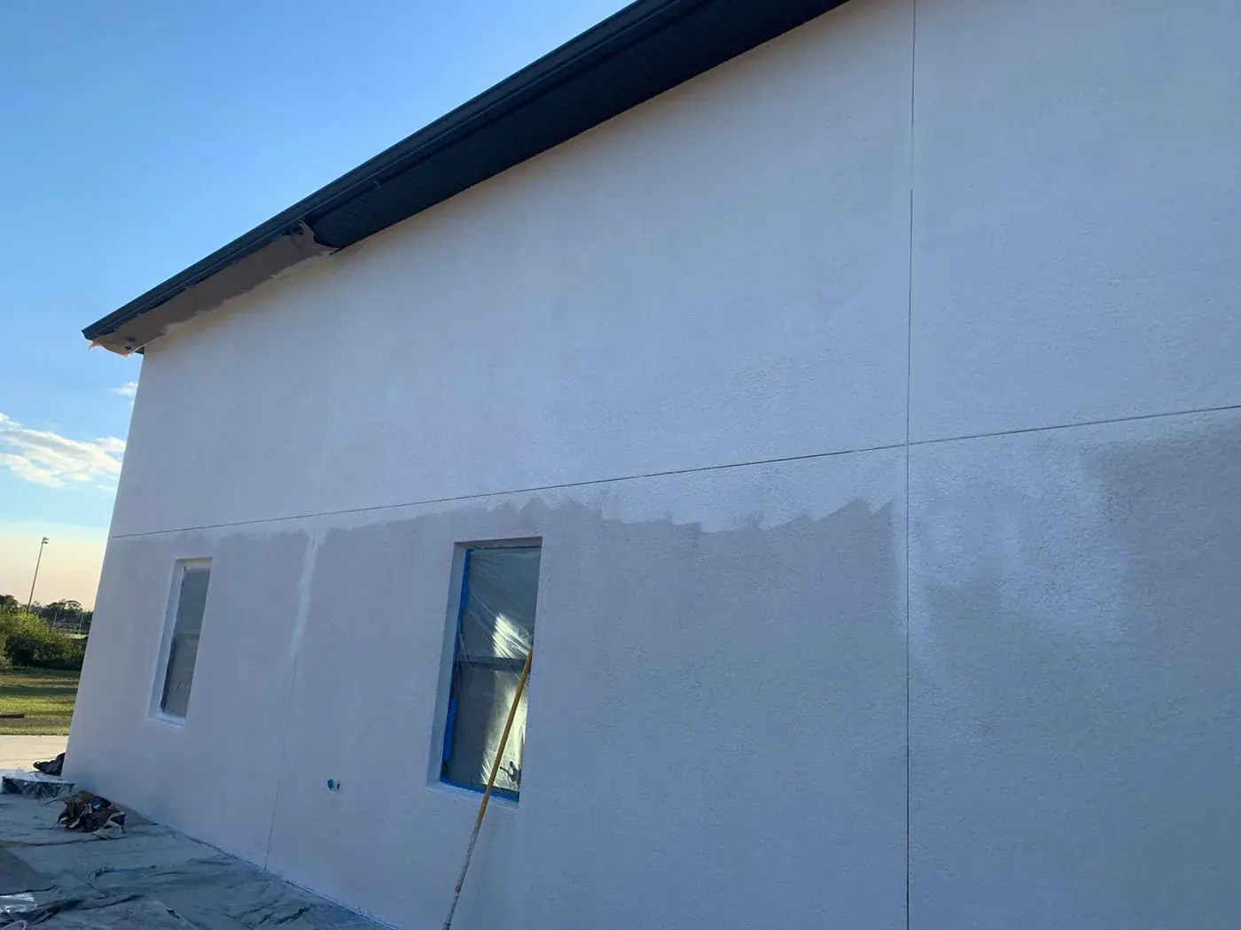 Large stucco wall halfway through its second coat