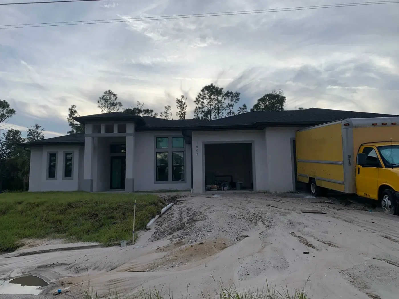 Work truck parked at a Florida new build during the exterior paint stage