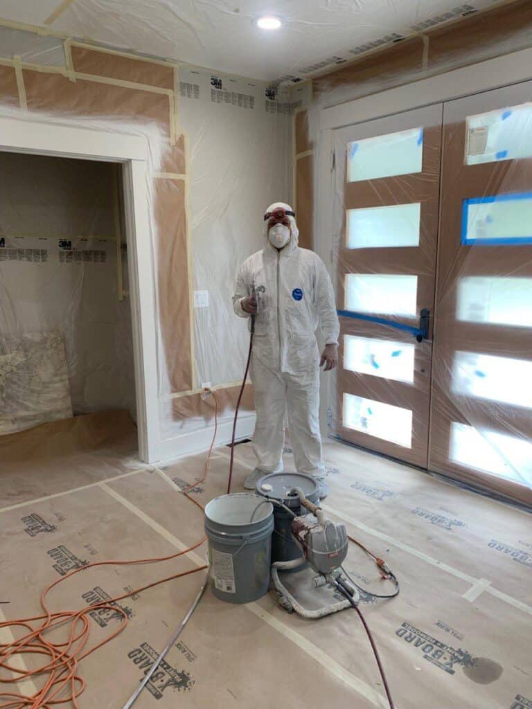 Professional painting contractor in South Florida using protective equipment during interior painting